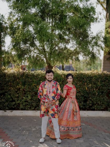 A happy, walking portrait of the couple in their colorful Sangeet attire.
