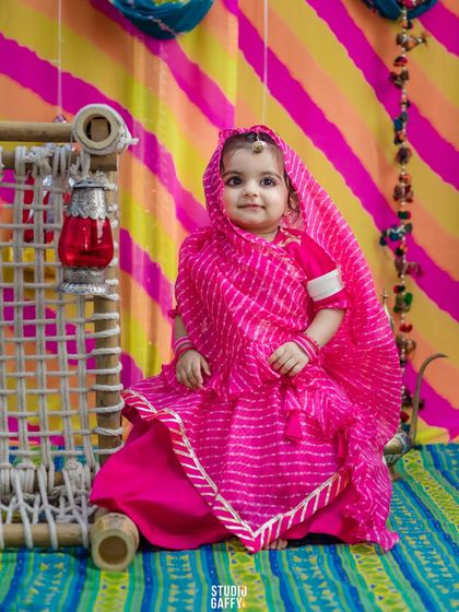 A full-length portrait of our little Rajasthani princess next to a miniature charpai (cot).