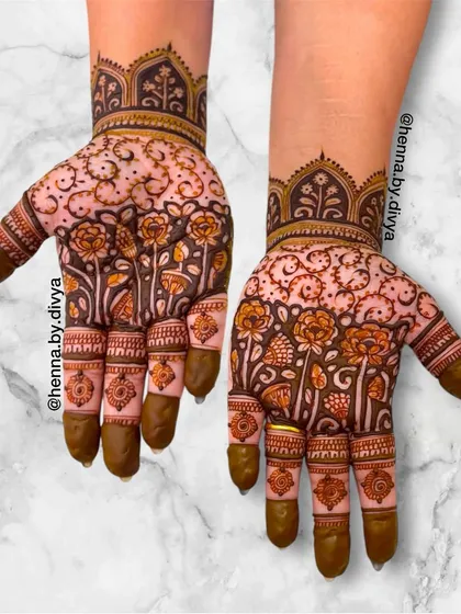 This design features a garden of flowers growing up the hand, creating a beautiful and organic pattern. The intricate details in each flower and leaf showcase the artistry involved.