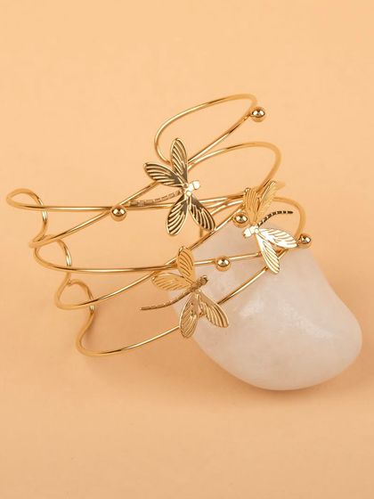 The dragonfly cuff bracelet styled on a white stone.