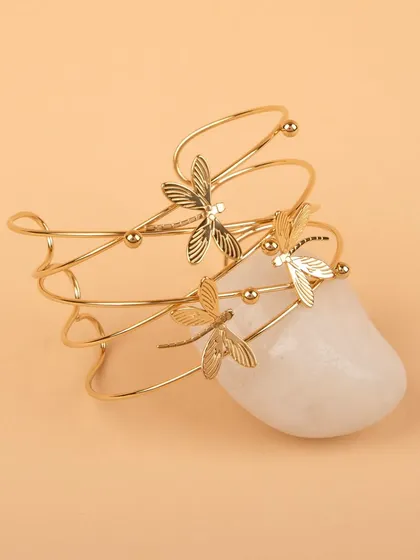The dragonfly cuff bracelet styled on a white stone.