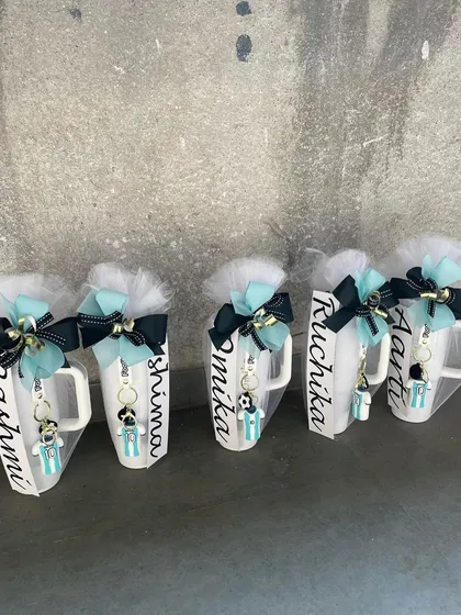 A set of personalized mugs for a party, all featuring a light blue and white color scheme. This shows how we can create a unified look for all your party favors.