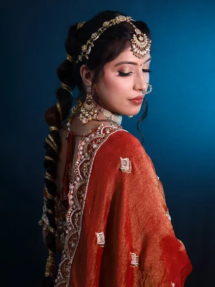 An elegant bridal look featuring a braided hairstyle and traditional jewelry. Our courses often include hairstyling to ensure our students can offer a complete package.