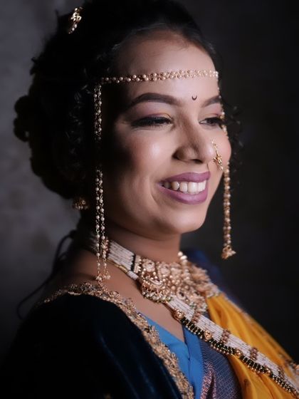 A close up of a smiling bride wearing a Mundavalya. Her makeup is soft and glowing, perfect for a daytime wedding ceremony.