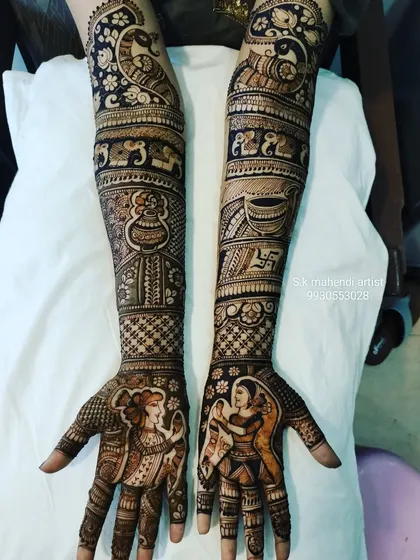 Getting ready for Navratri? I can create designs with festive figures like these Dandiya dancers. This full-arm mehendi also includes traditional elements like a kalash, swastika, and peacock.