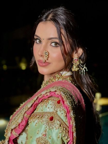A close-up that captures the soul of the look. The defined eyes, traditional nath, and soft lip color create a captivating and modern bridal portrait.