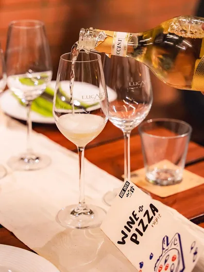 Pouring a glass of sparkling wine to kick off our Wine and Pizza Night.