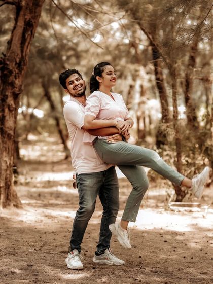 A fun and energetic pre-wedding shot of a couple, with the groom lifting the bride in a playful moment.