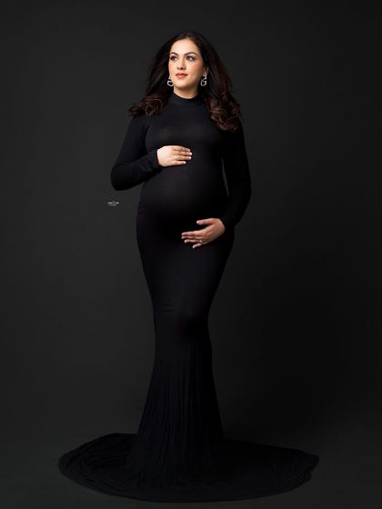 A full-length standing portrait in a sleek black gown. This black and white shot is the definition of timeless elegance.