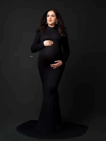 A full-length standing portrait in a sleek black gown. This black and white shot is the definition of timeless elegance.