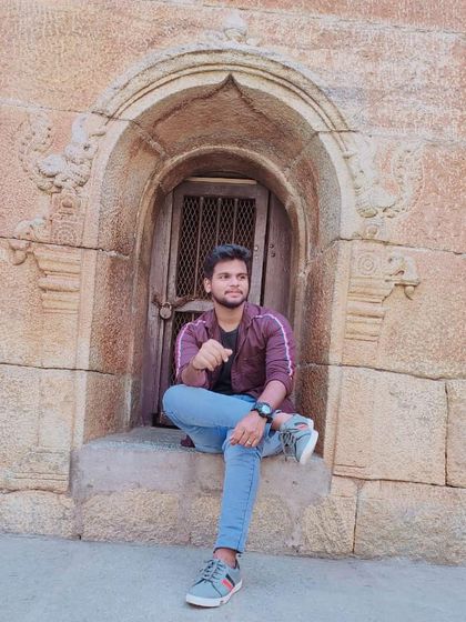 Finding a quiet spot in a carved stone window, likely at a historical site like Bangalore Palace or a similar fort.