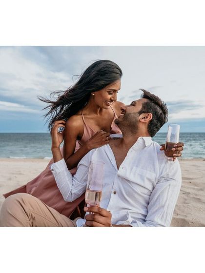 A playful and romantic moment from a beach pre-wedding shoot, capturing the couple's joy and affection.