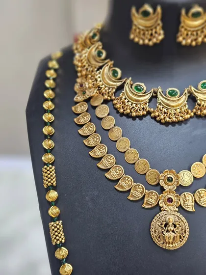 A close-up showing the Goddess Laxmi motif on the coin haar, a symbol of prosperity for the new bride.