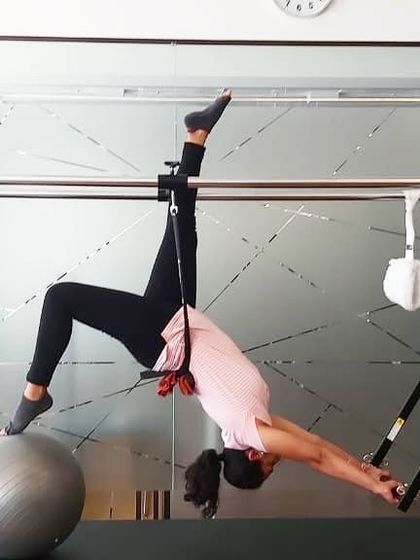 Another shot of our client using the Cadillac and stability ball. Her testimonial highlights how Pilates provides functional strength for real-life activities.