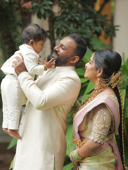 A tender moment between father, mother, and child. Their matching cream outfits create a serene and loving family portrait.