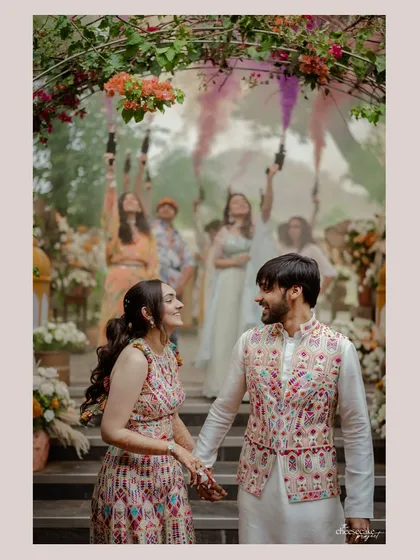 Let's make an entrance! Capturing the energy and color of a grand couple's entry, surrounded by their cheering friends and family, sets the tone for the celebration.