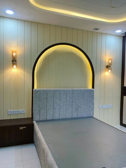 This parent's bedroom in our Sobha HRC project features an arched headboard with backlighting and fluted panels. The design is simple, elegant, and creates a peaceful atmosphere.