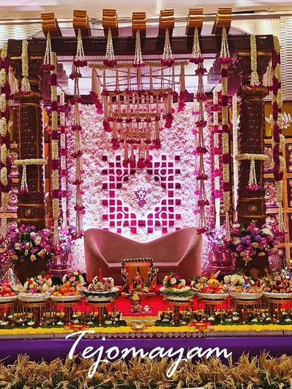 A grand baby shower setup with a temple-style backdrop and an extensive display of offering plates, creating a divine and opulent look.