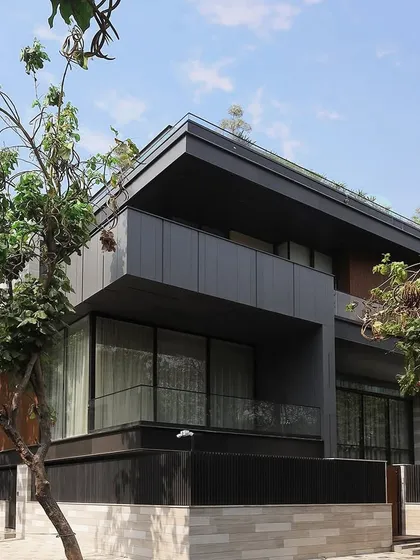 Clean horizontal lines and cantilevered slabs establish a strong architectural language for this modern residence. The facade thoughtfully layers glass, metal, and vertical fins to balance a feeling of openness with necessary privacy.