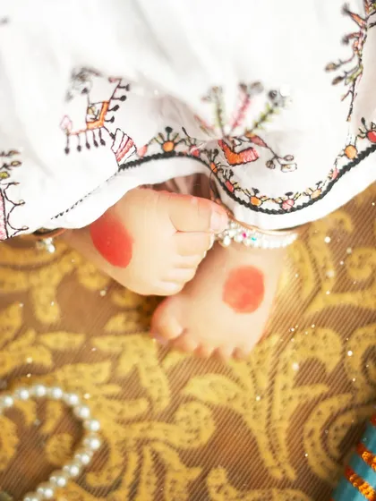 A close up on the tiny feet adorned with alta, a beautiful detail from our Navratri themed shoot. It's these small cultural touches that make a session truly special.