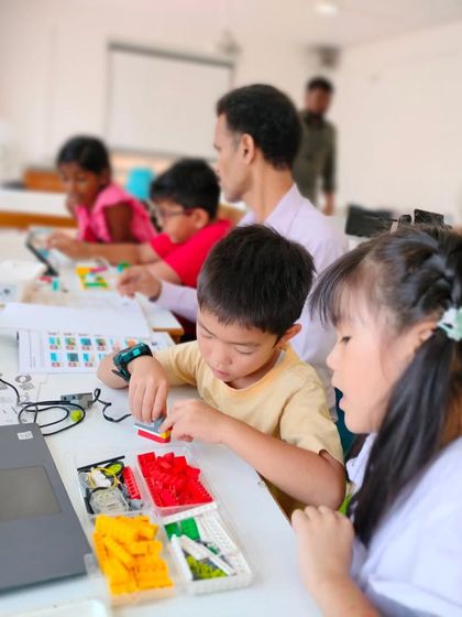 A candid shot of our summer camp, where students are busy at their tables building and coding their unique creations.