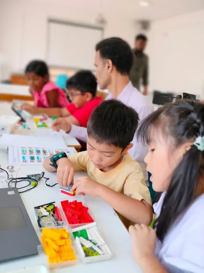 A candid shot of our summer camp, where students are busy at their tables building and coding their unique creations.