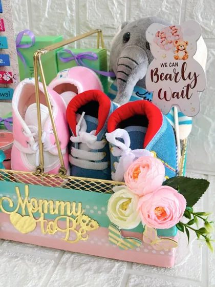 A detailed shot of the "We Can Bearly Wait" baby shower hamper. You can see the soft texture of the plush toy and the delicate flowers that add a touch of elegance.
