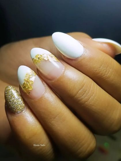 At my studio, perfection is key. This design features a white base with gold foil and a full-coverage gold glitter accent nail. It's glamorous without being over the top.