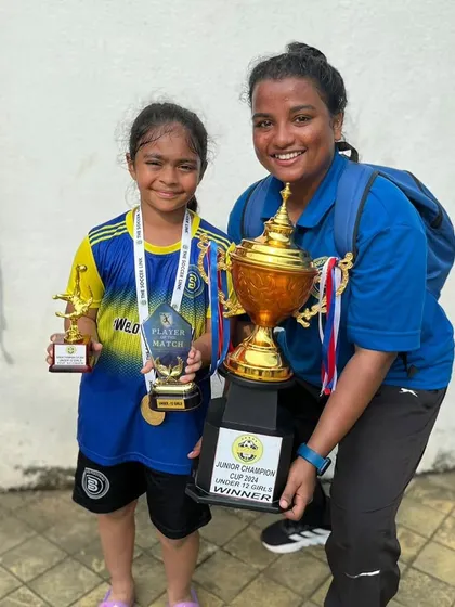 A player and her coach with the trophies. A proud moment for our U12 Girls team.