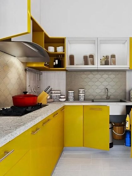 A vibrant yellow modular kitchen that brings energy and cheerfulness to the home. The design includes frosted glass cabinets and smart corner solutions to make the most of the space.