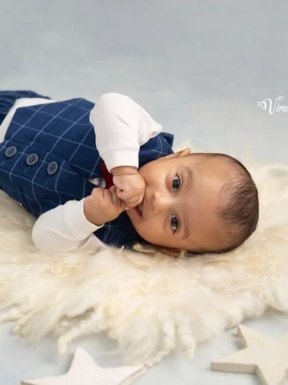 A shy moment among the stars. This tender infant portrait captures the baby's sweet and curious expression during his cloud and stars themed session.