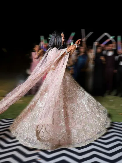 A motion-blur shot of the bride twirling on the dance floor during her Sangeet night, capturing the movement and joy of her performance.