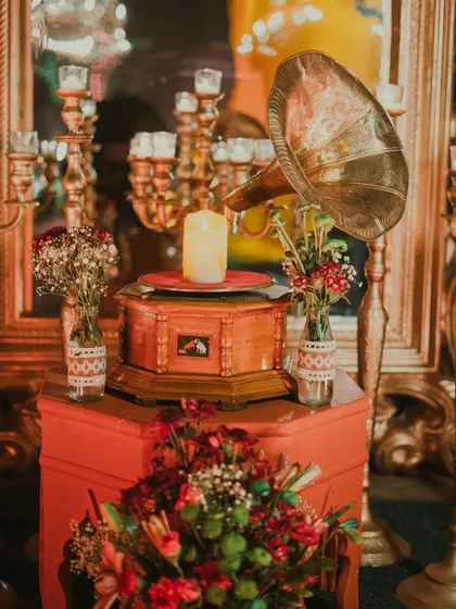 Details that tell a story. A vintage gramophone, surrounded by the warm glow of candles and rich red florals, adds a touch of timeless romance to a modern cocktail party. It's this fusion of old and new that makes an event truly special. 🥂