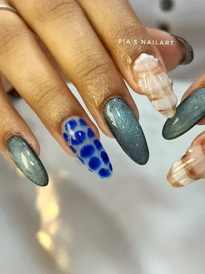 Let's get creative with textures. This ocean-themed set combines a shimmering cat eye effect with 3D water droplets and sculpted acrylic seashells. It’s a vacation for your hands.