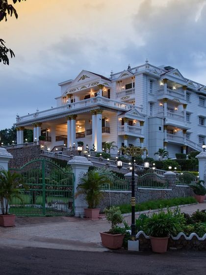 The grand entrance of the palace at dusk, with landscape lighting creating a warm and inviting welcome.