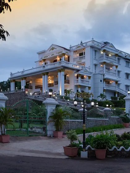 The grand entrance of the palace at dusk, with landscape lighting creating a warm and inviting welcome.