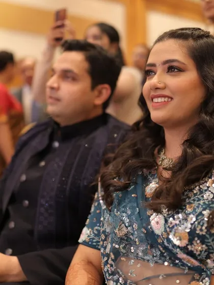The happy couple enjoying the performances at their Sangeet, their smiles reflecting the joyous atmosphere of the event.