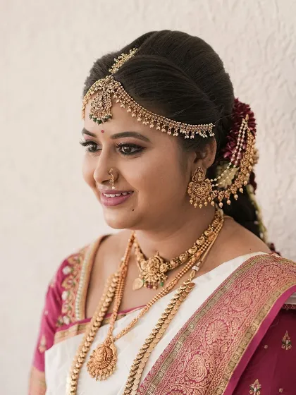 A side profile of this lovely Brahmin bride, showing her intricate hairstyle and the smooth finish of her makeup.