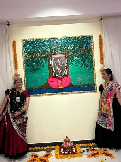 Two of our members standing before the beautiful Linga Bhairavi artwork during our Navratri celebration, a night filled with devotion and dance.