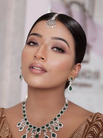 A soft bridal glam look on a beautiful dusky skin tone. The makeup is designed to create a golden goddess glow, proving that soft, radiant makeup looks stunning on every complexion.