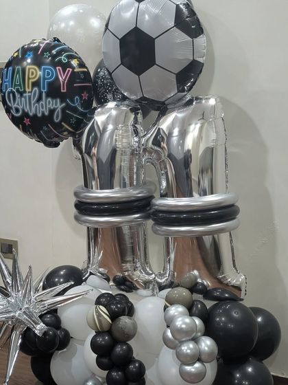 A football-themed balloon bouquet for an 11th birthday, featuring a large soccer ball foil balloon and silver number balloons.