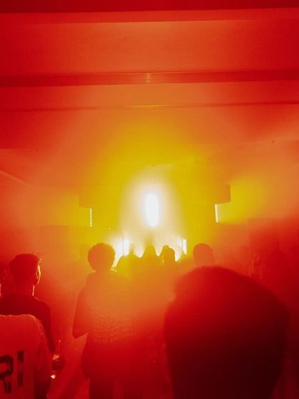 The entrance to the dance floor, with the crowd silhouetted against a blast of red light. It's an invitation to step into a different world for the night.