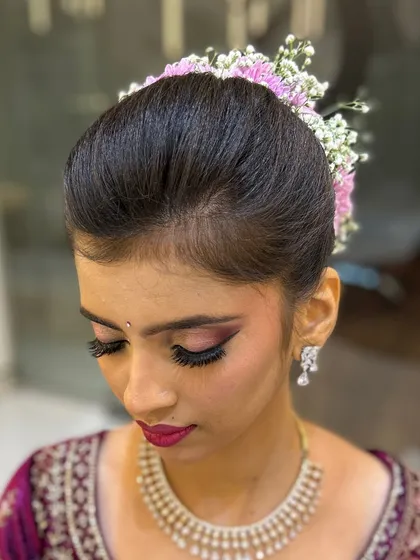 A close-up of the bridal makeup, highlighting the flawless eye makeup and elegant hair styling.