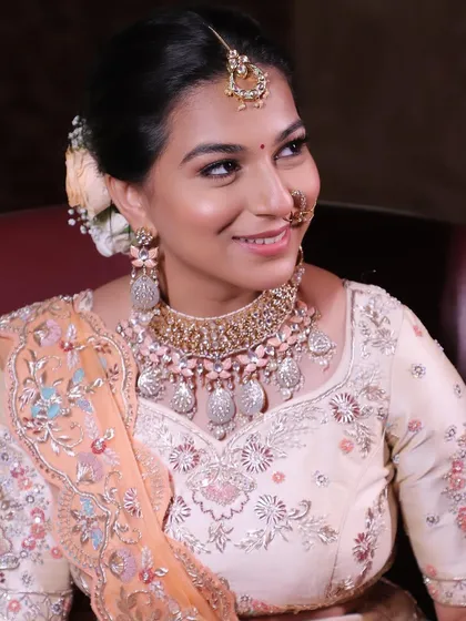 A happy, glowing Rakshika on her wedding day. The soft makeup look perfectly complements her pastel outfit and radiant smile.