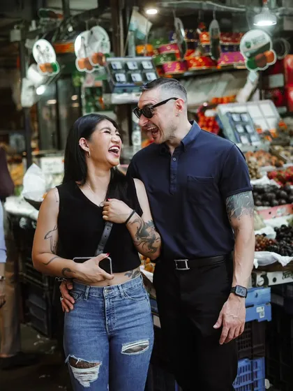Capturing love in unexpected places, like a bustling Mumbai fruit market. This candid shot is full of life, color, and authentic laughter.