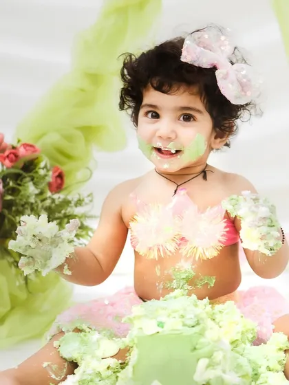 Offering a piece of cake to the camera. The interactive and playful nature of these shoots allows for so many cute and funny moments.