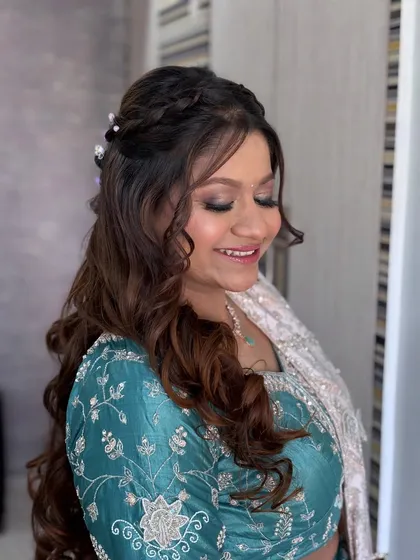 A beautiful close-up of a soft glam look. The client is smiling, and her eyes are sparkling with a hint of teal shimmer.