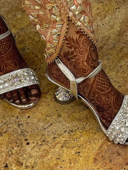 Both feet with henna and sandals, giving a complete picture of the bridal look.