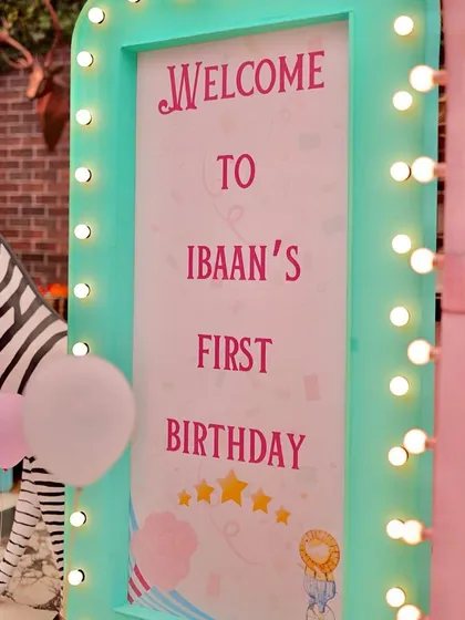 A close-up of the marquee welcome sign for Ibaan's first birthday, with a zebra prop peeking from the side. The combination of lights and props creates an exciting entrance.