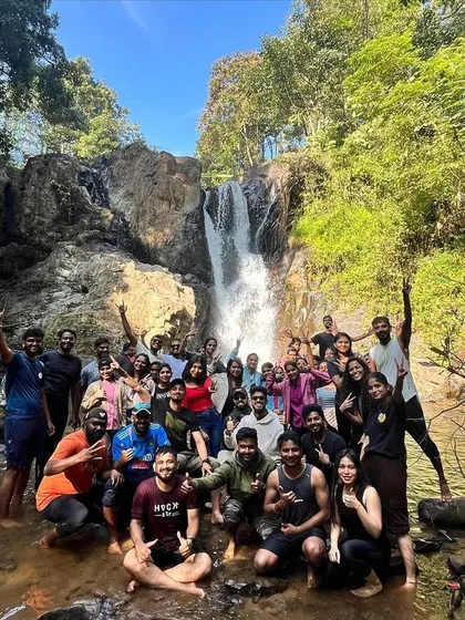A happy group photo at a waterfall during our Netravati trek.